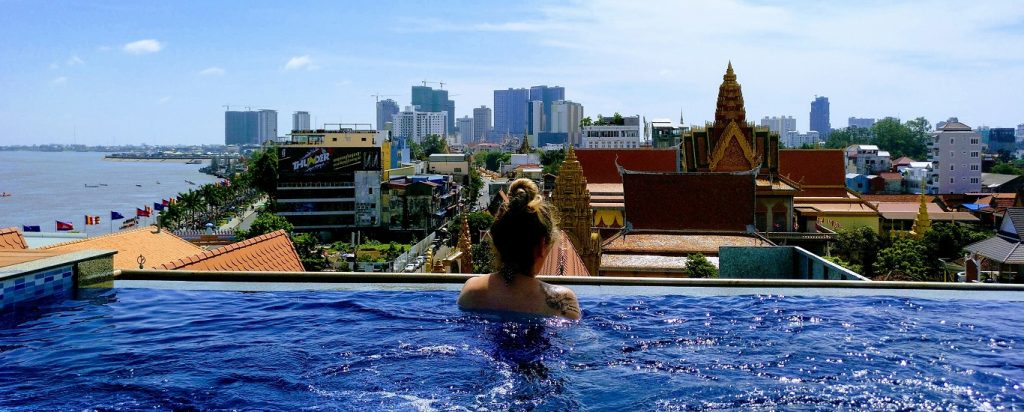 Woman sunbathing on rooftop pool overlooking Tonle Sap - Mekong River and Phnom Penh